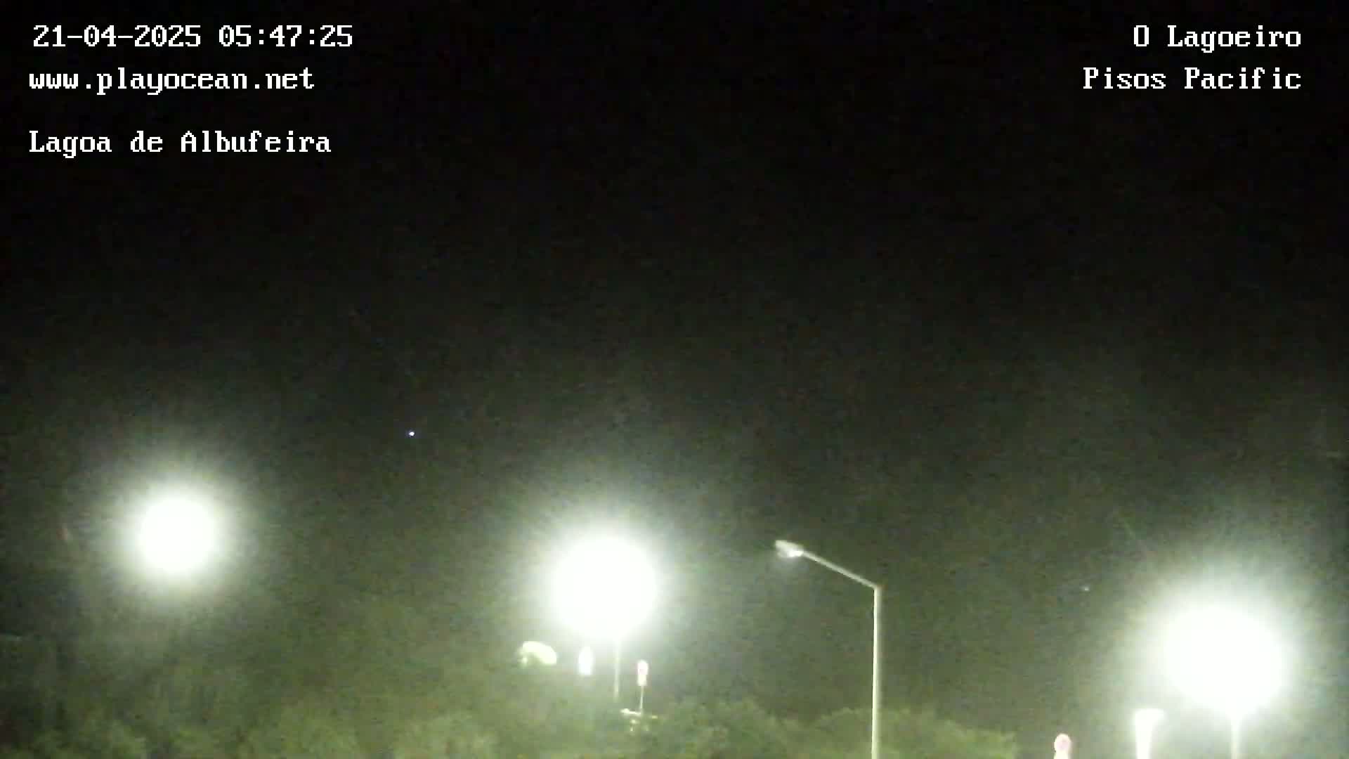 At night, several bright lights illuminate a dark landscape under a clear, starlit sky.