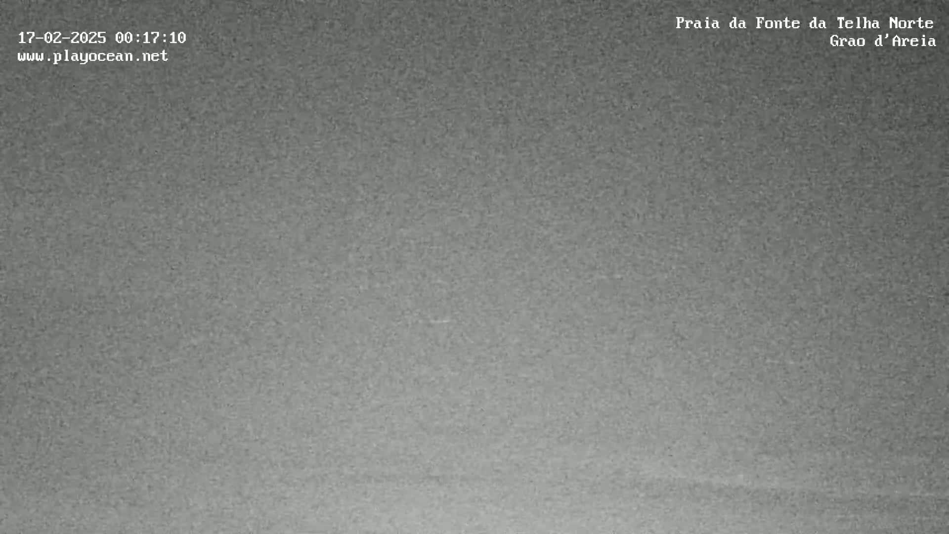 A grainy, dark gray image shows an overcast sky at night.
