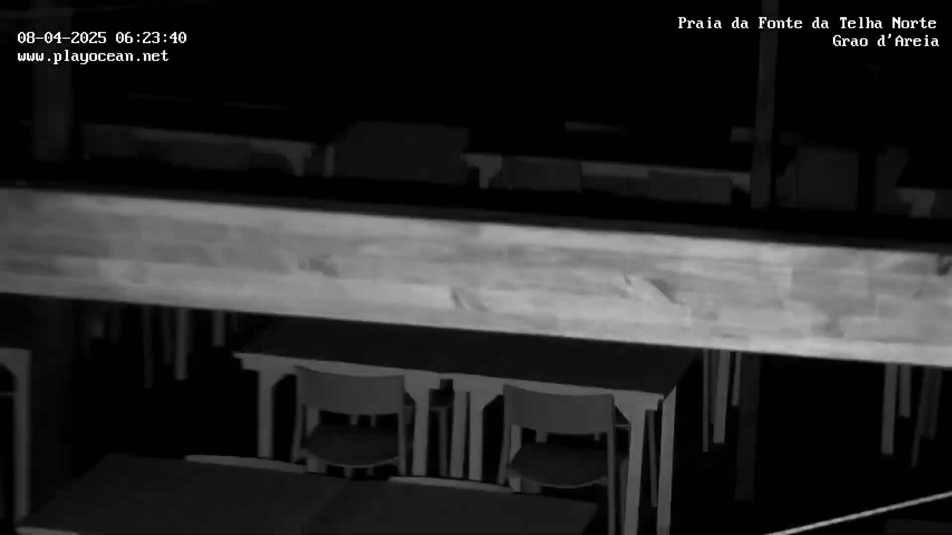 A dimly lit, indoor space shows several chairs and tables viewed from above.