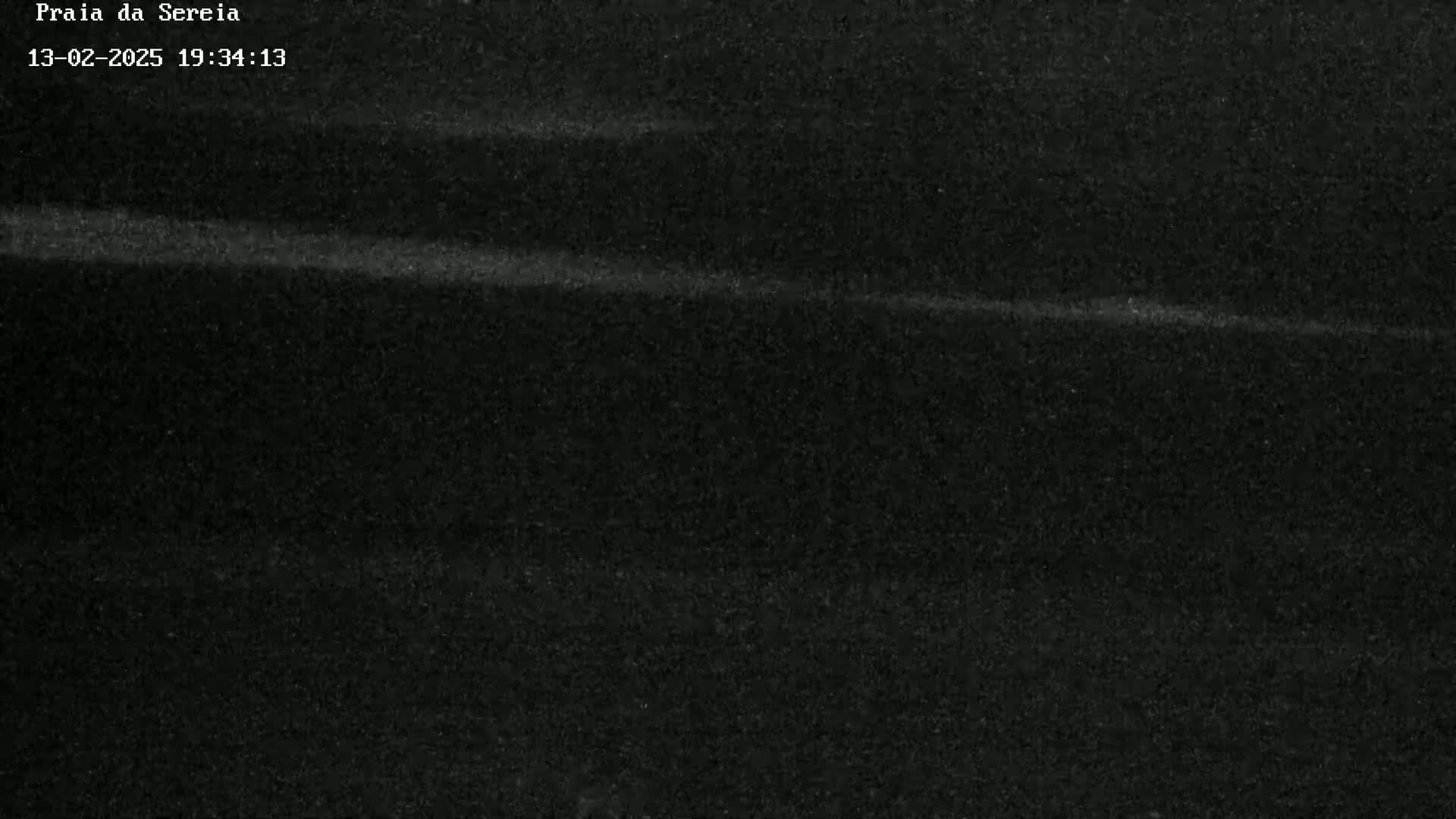 A dark, grainy image shows a faint, horizontal light streak across a mostly black background.