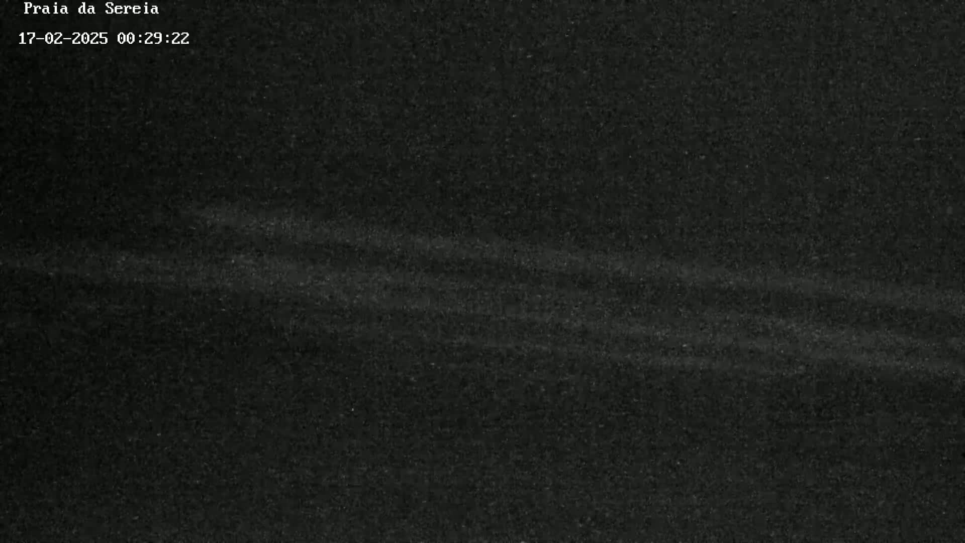 A dark, grainy image shows subtle horizontal streaks of lighter gray across a mostly black background.