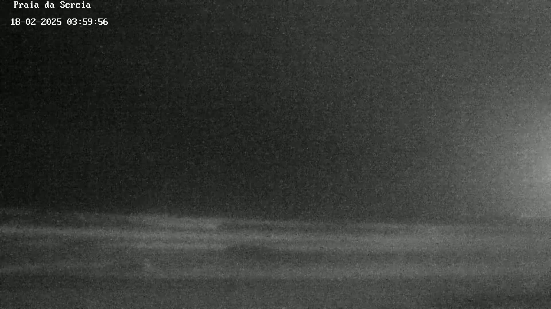 A dark, grainy image shows a flat, dark surface under a dark sky.