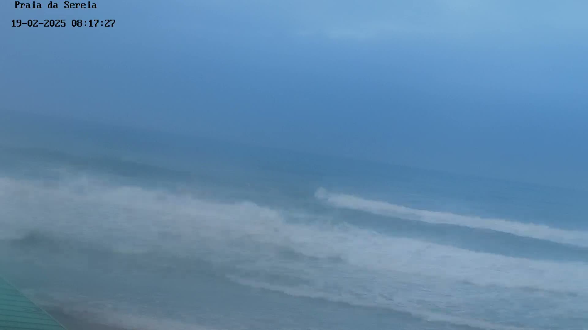 A hazy, overcast sky overlooks a turbulent ocean with choppy waves.