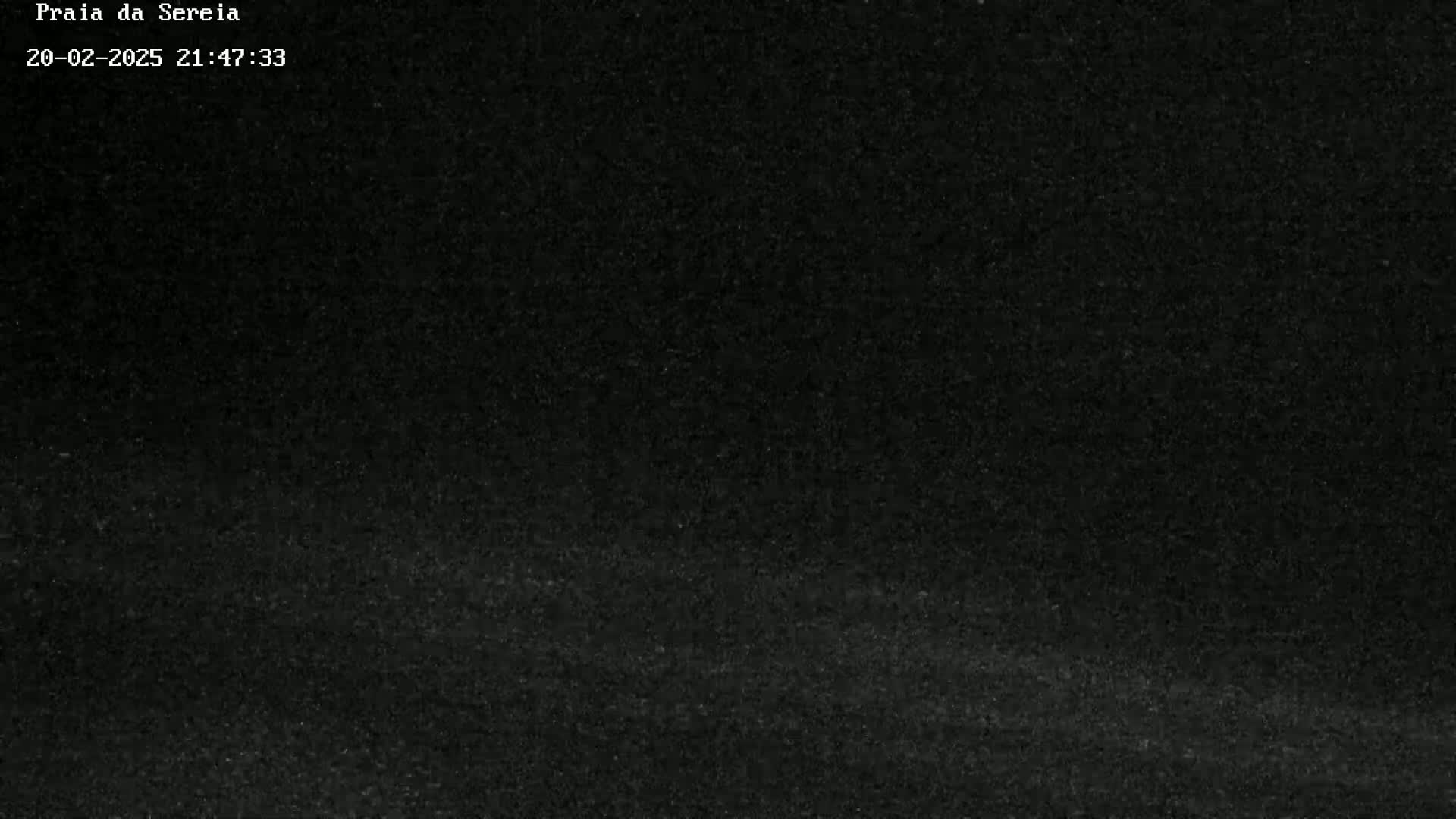A very dark, grainy image shows a mostly black, possibly nighttime scene.