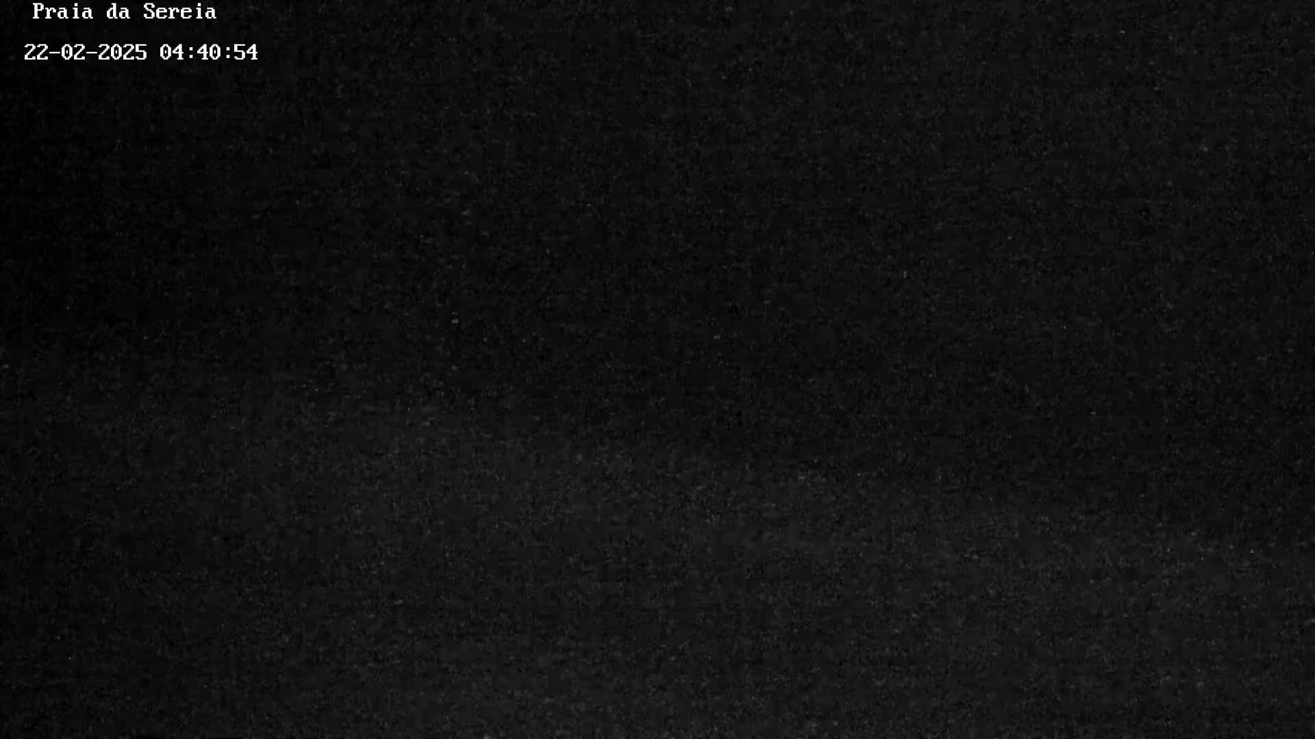 A dark, grainy image shows a mostly black, possibly nighttime scene.
