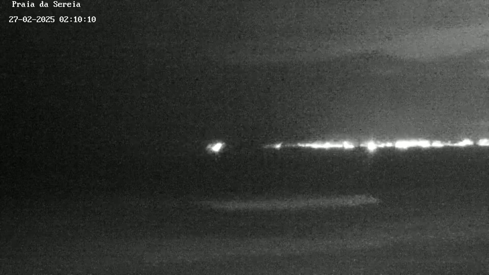 A nighttime, low-light view of a distant horizon with a line of lights possibly indicating a town or city.