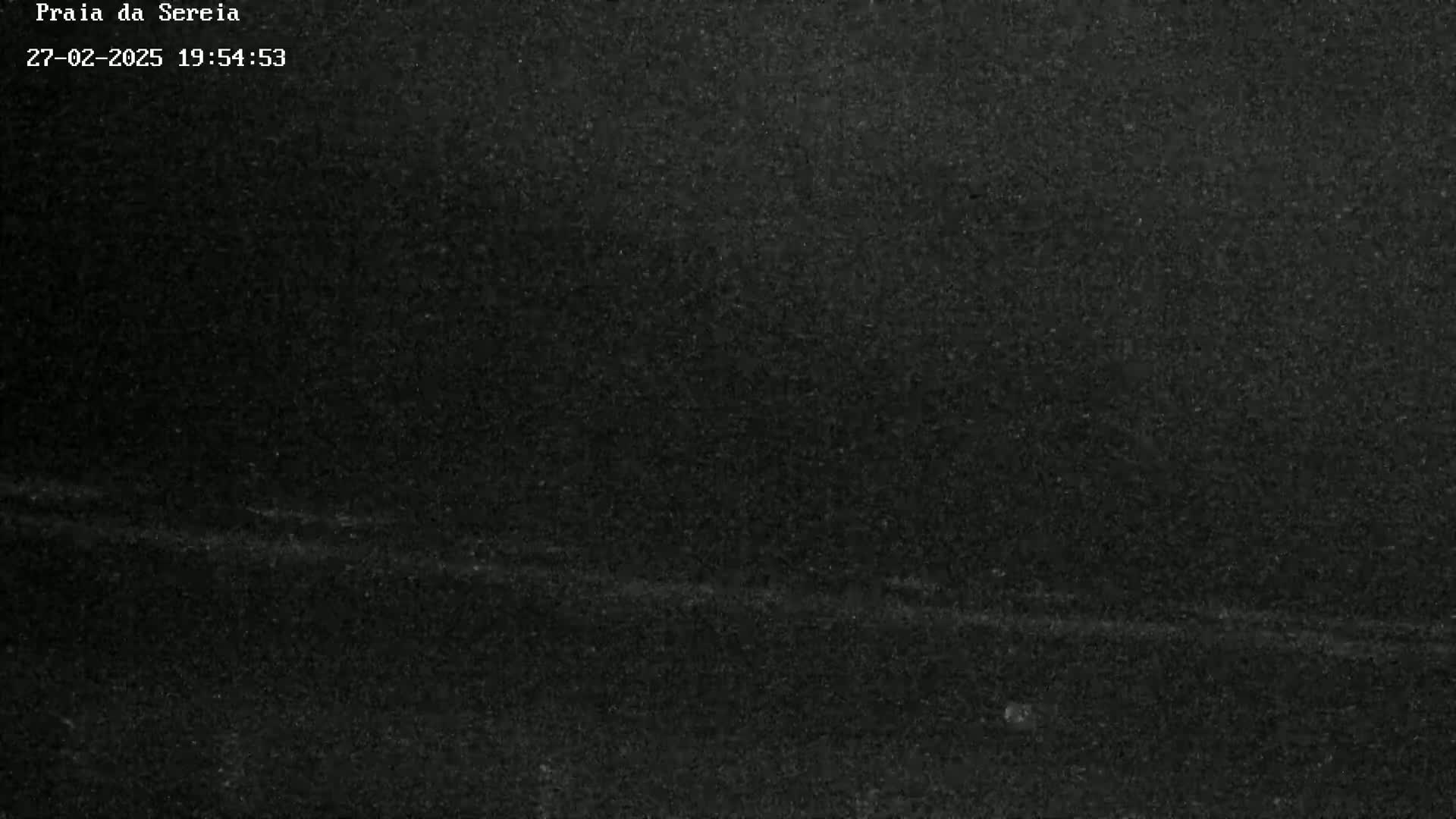 A dark, grainy image shows a mostly uniform black surface with faint, lighter horizontal lines.