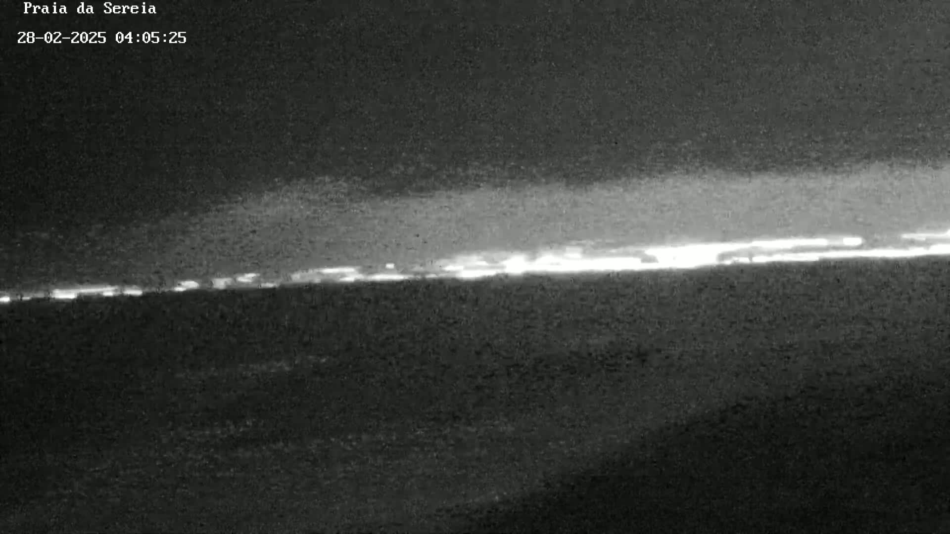 A low-light image shows a bright horizon line possibly indicating the sunrise or a distant city at night.