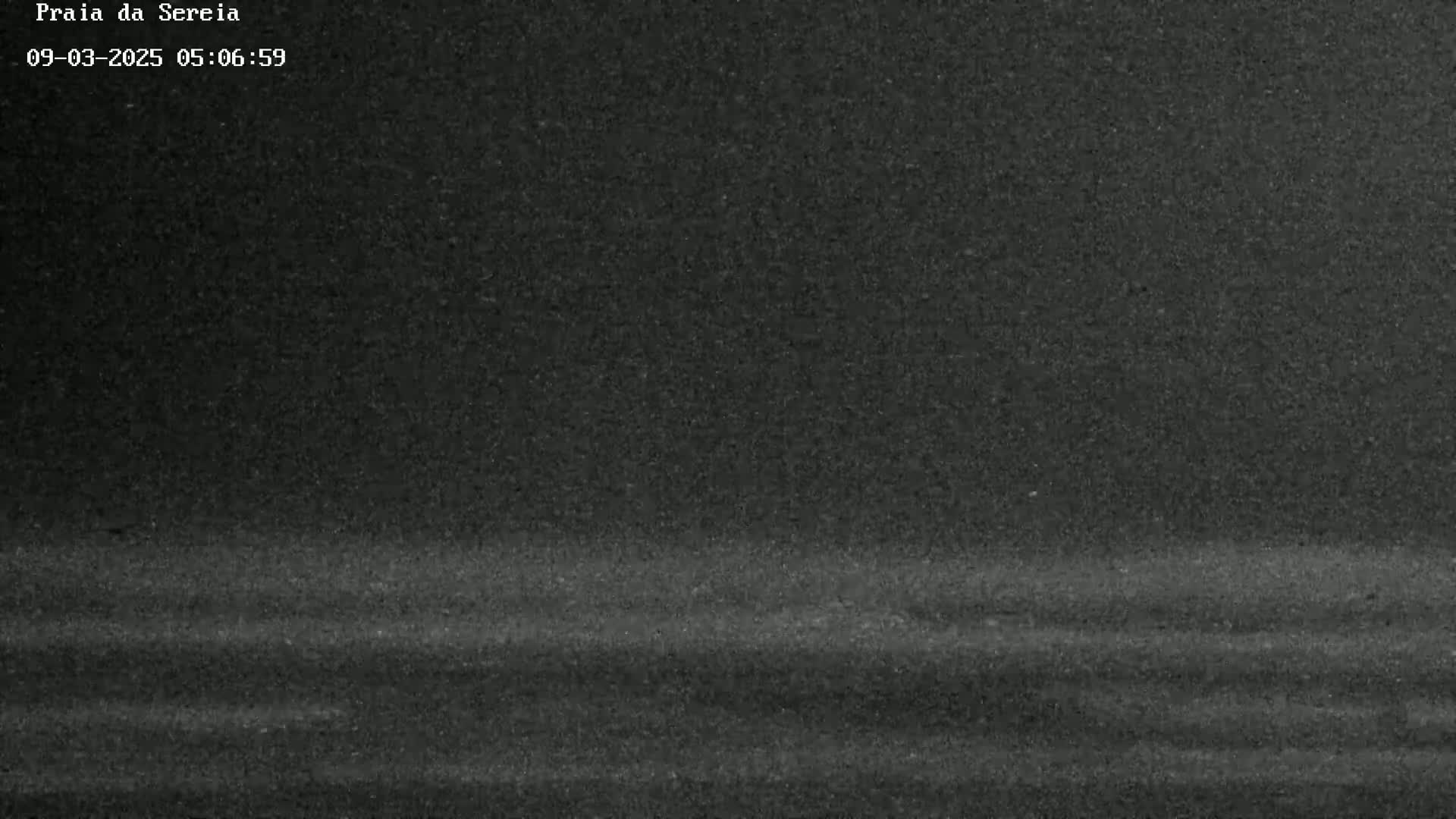 A dark, grainy image shows a mostly featureless, dark gray expanse that appears to be an overcast night sky or a dark road.