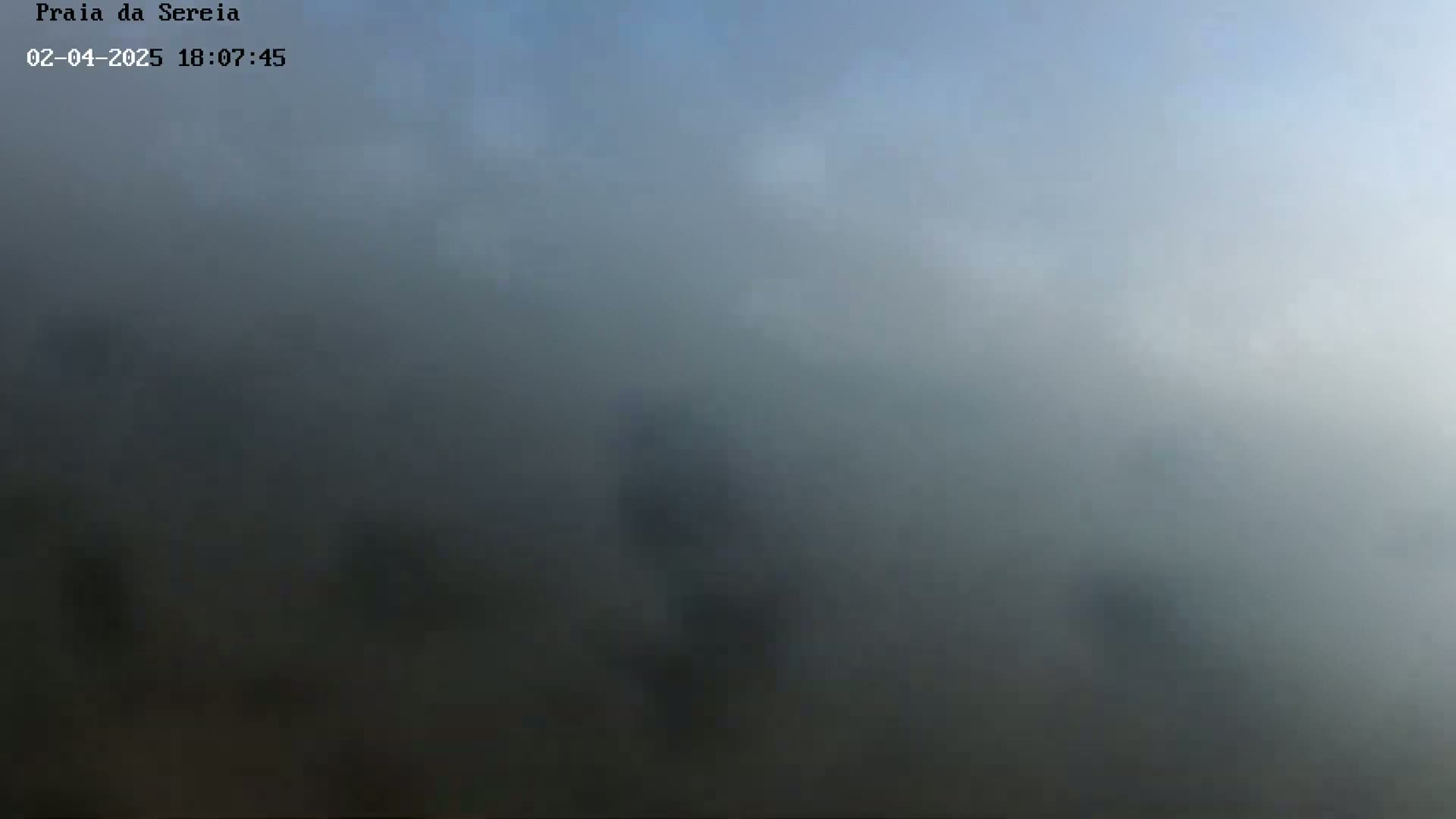 A foggy, hazy landscape is visible under a mostly clear sky.