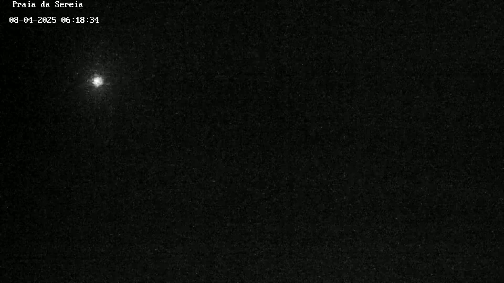 A bright light is visible in a dark, nighttime sky.