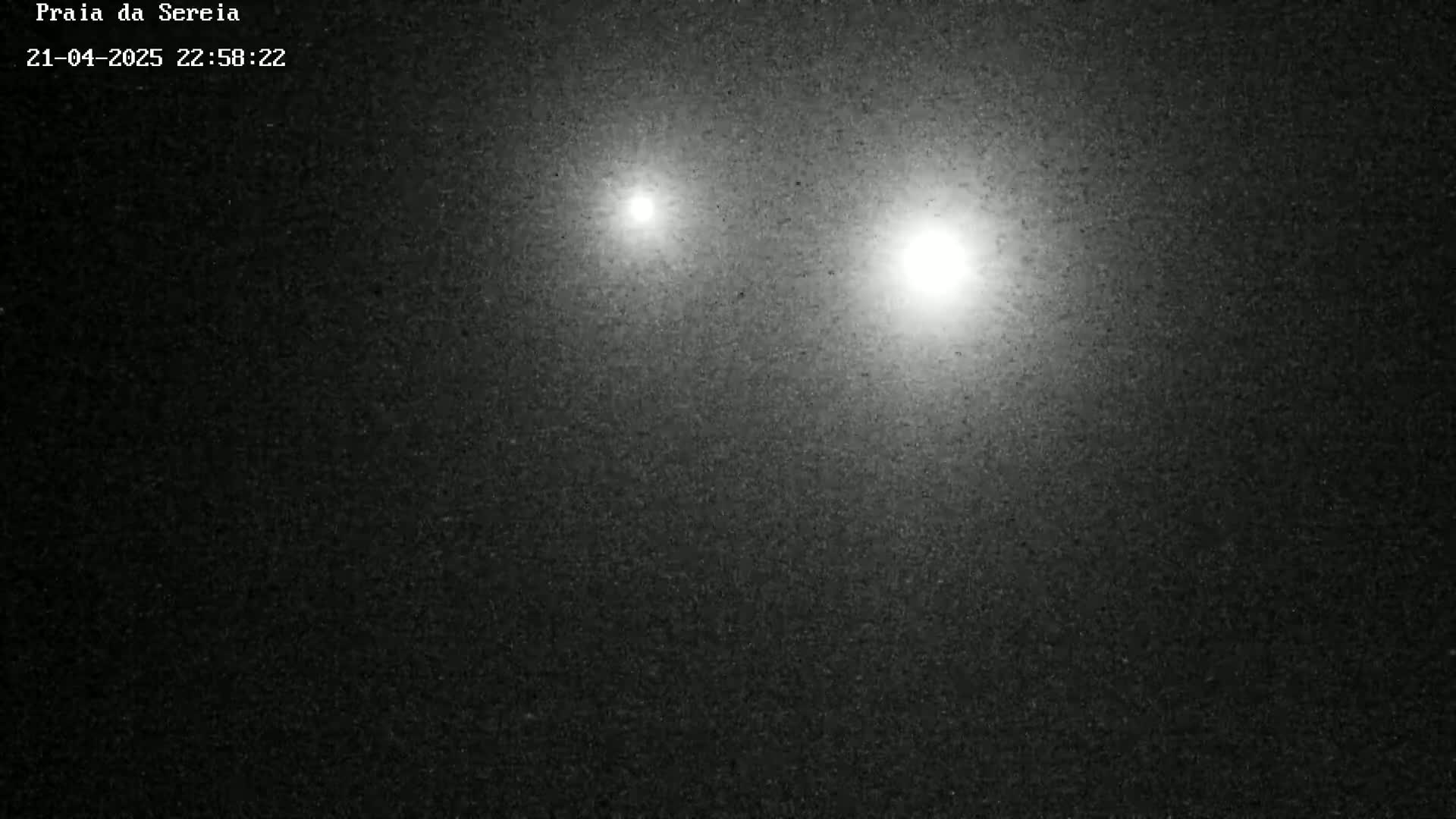 Two bright lights are visible in a dark, night sky.