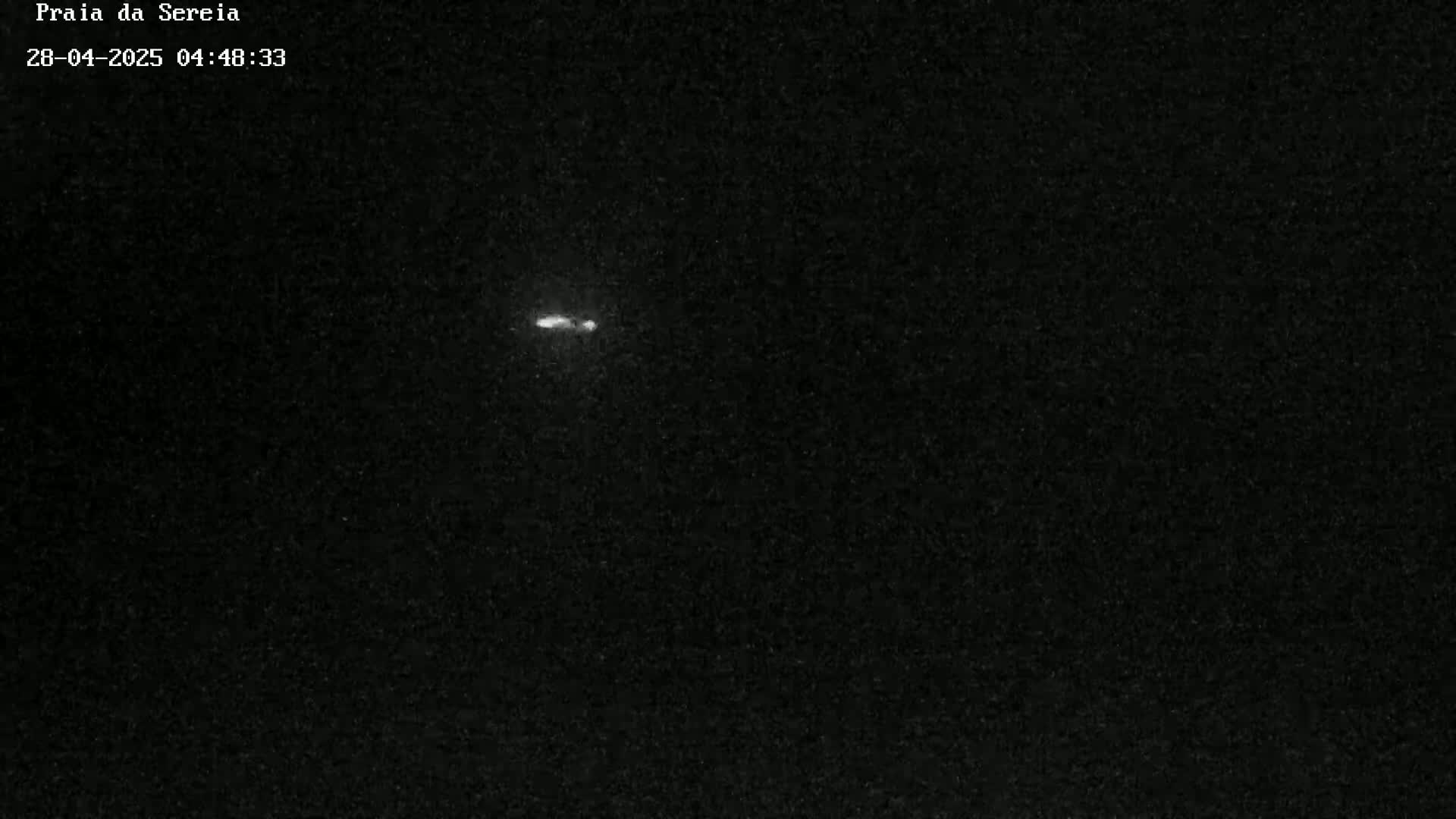 A small, bright streak is visible in the center of a dark, nighttime sky.