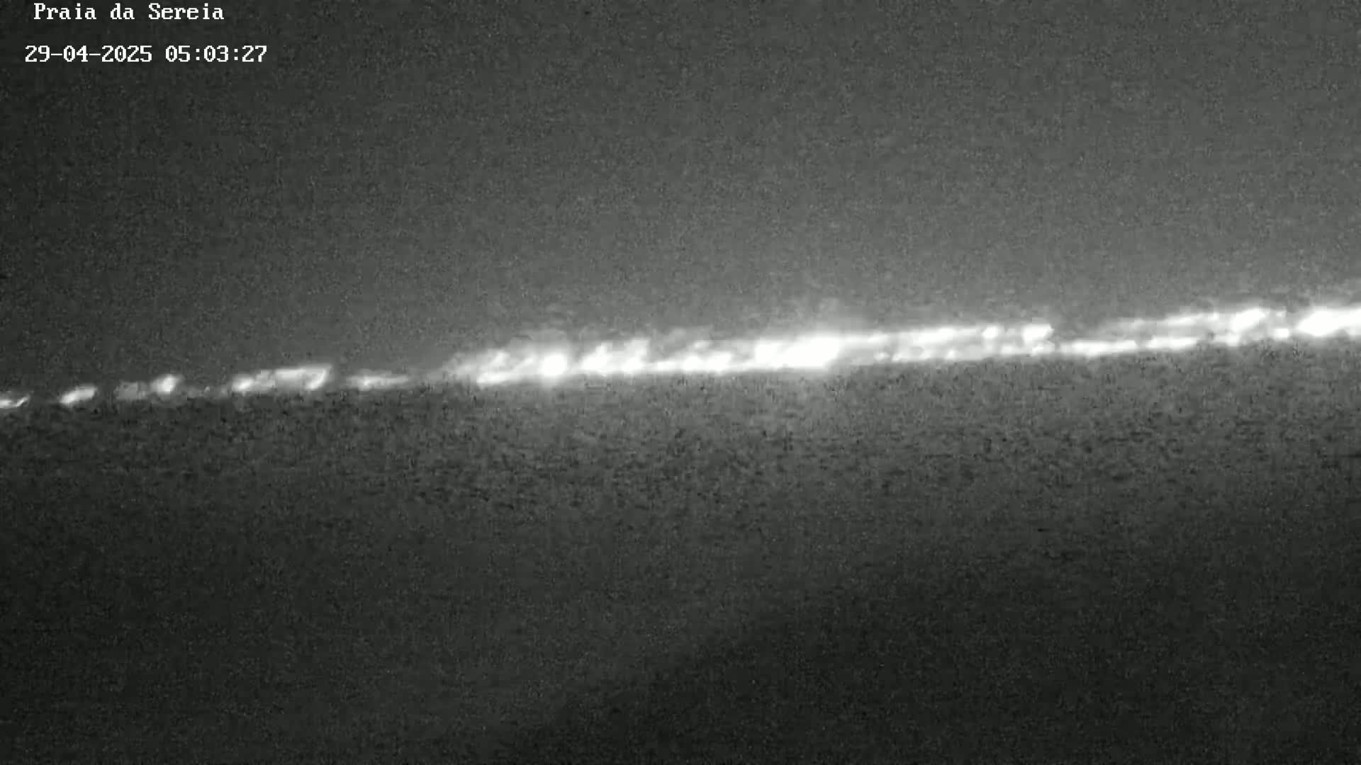 A long, thin line of lights is visible on the horizon at night.