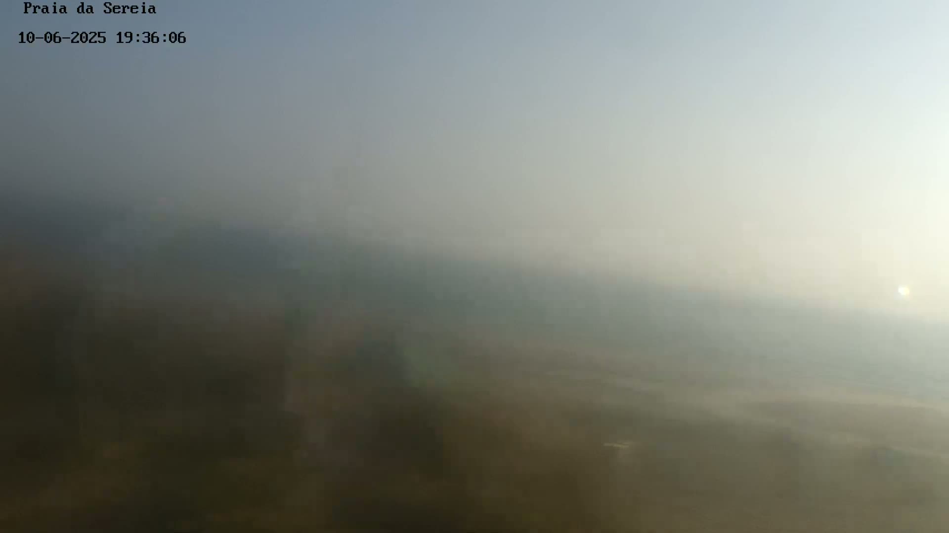 A hazy, sunlit landscape is visible in the distance, appearing somewhat obscured by atmospheric conditions.