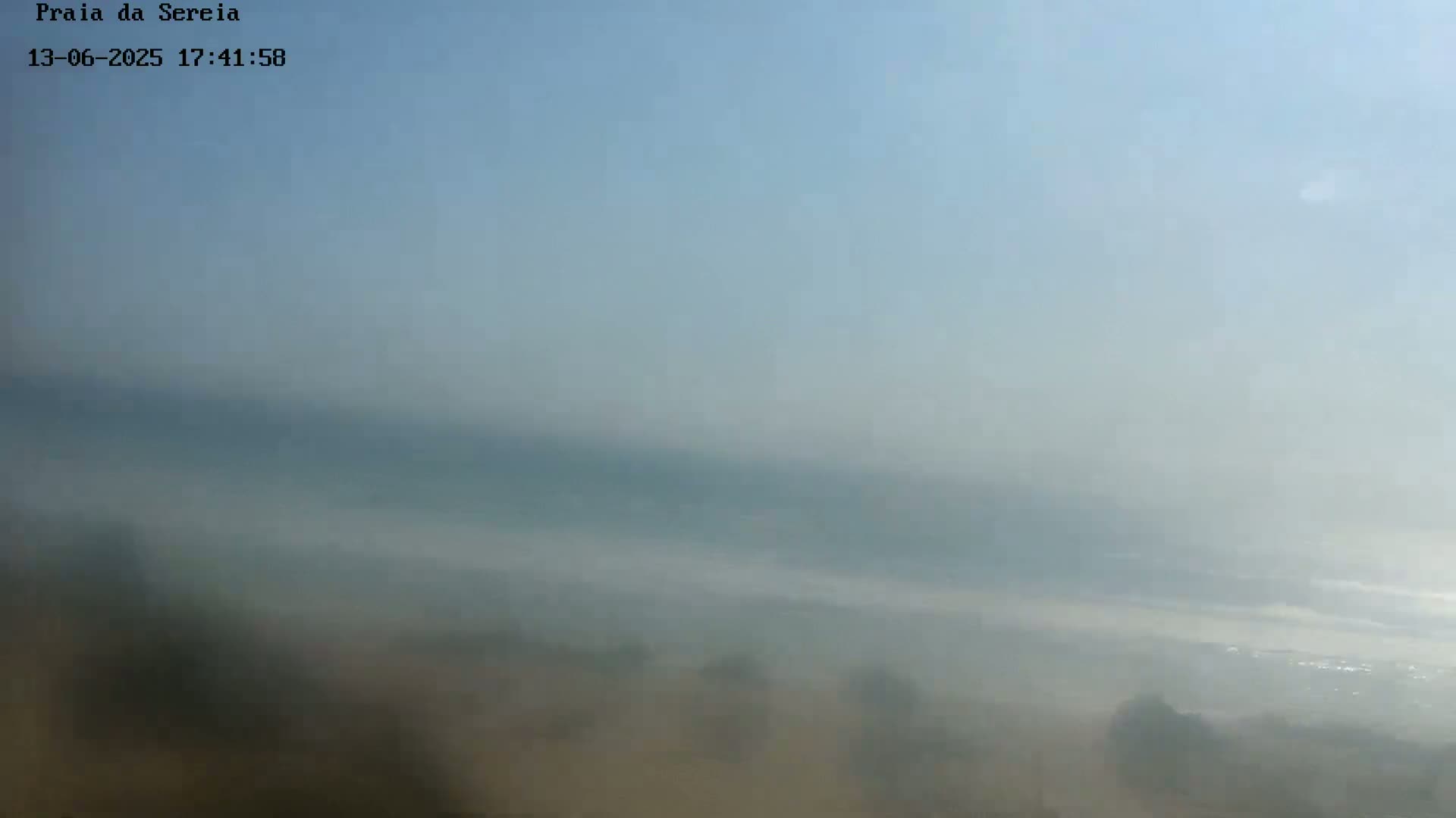 A hazy, possibly foggy, landscape stretches to a pale blue horizon.