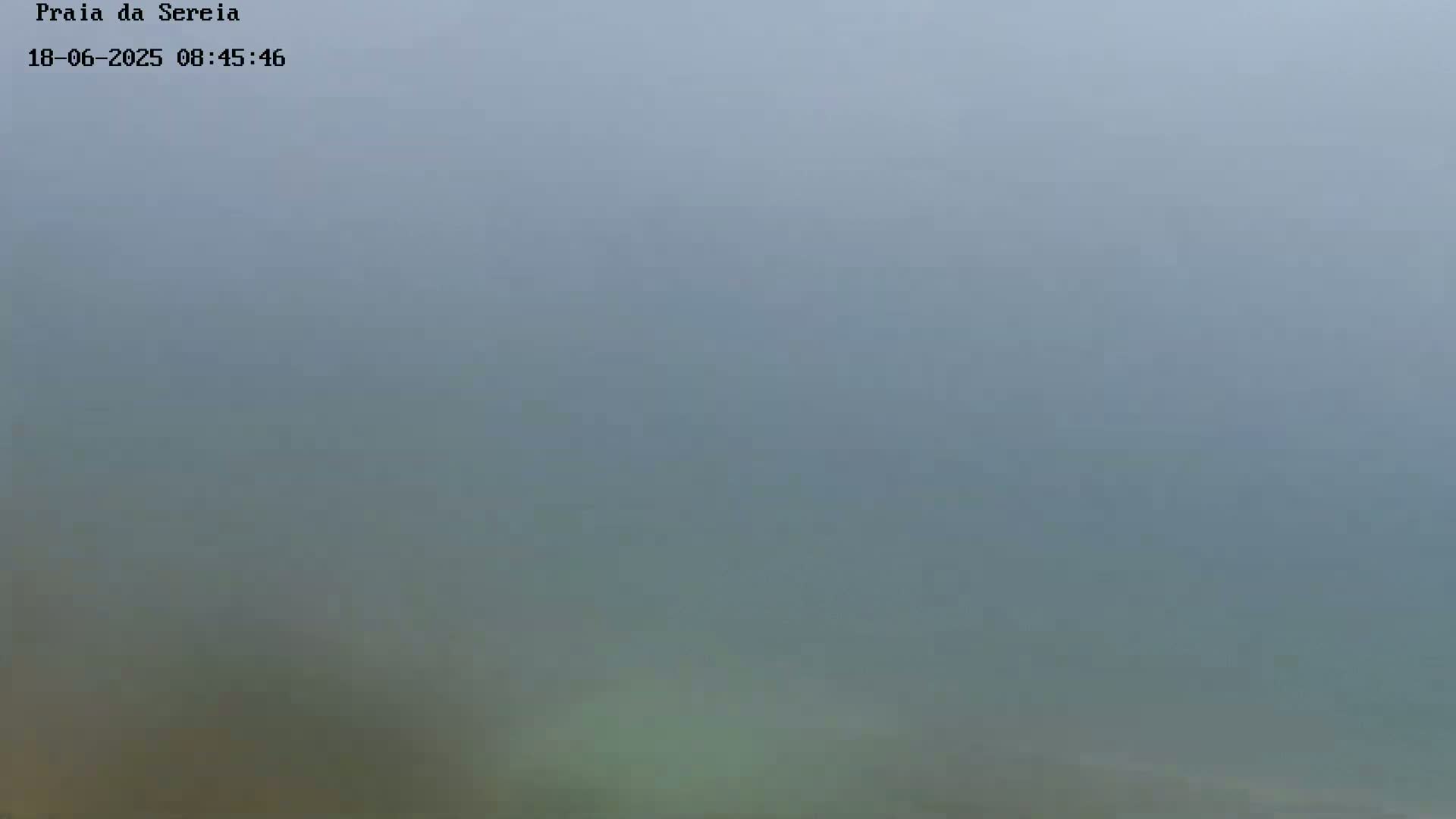 A very foggy or hazy scene obscures any details of the landscape.