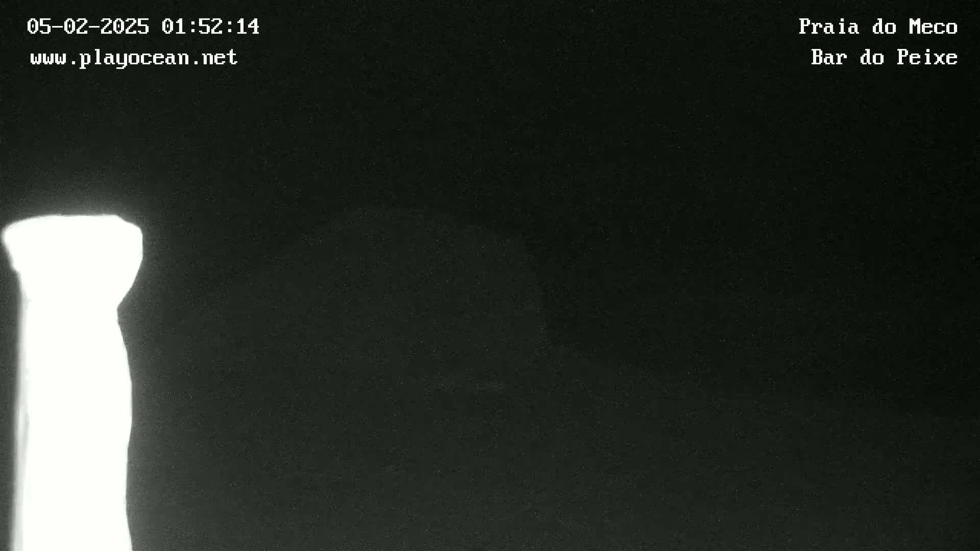 A brightly lit, vertical object is visible against a mostly dark background at night.