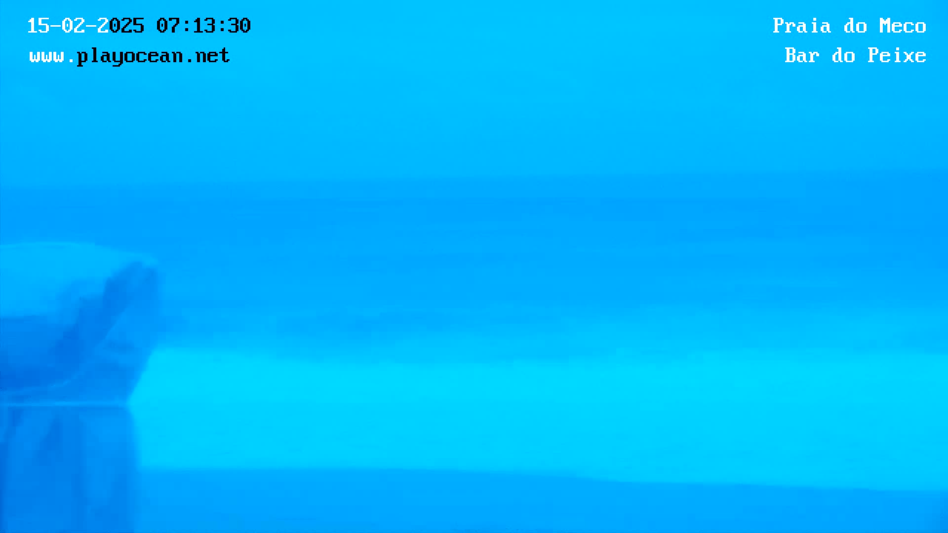 A blurry image shows a bright blue ocean under a clear sky.
