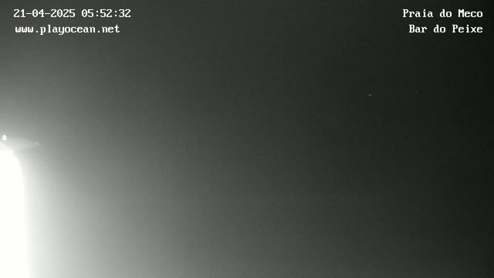 A nighttime, low-light image shows a mostly dark sky with a bright light source in the bottom left corner.