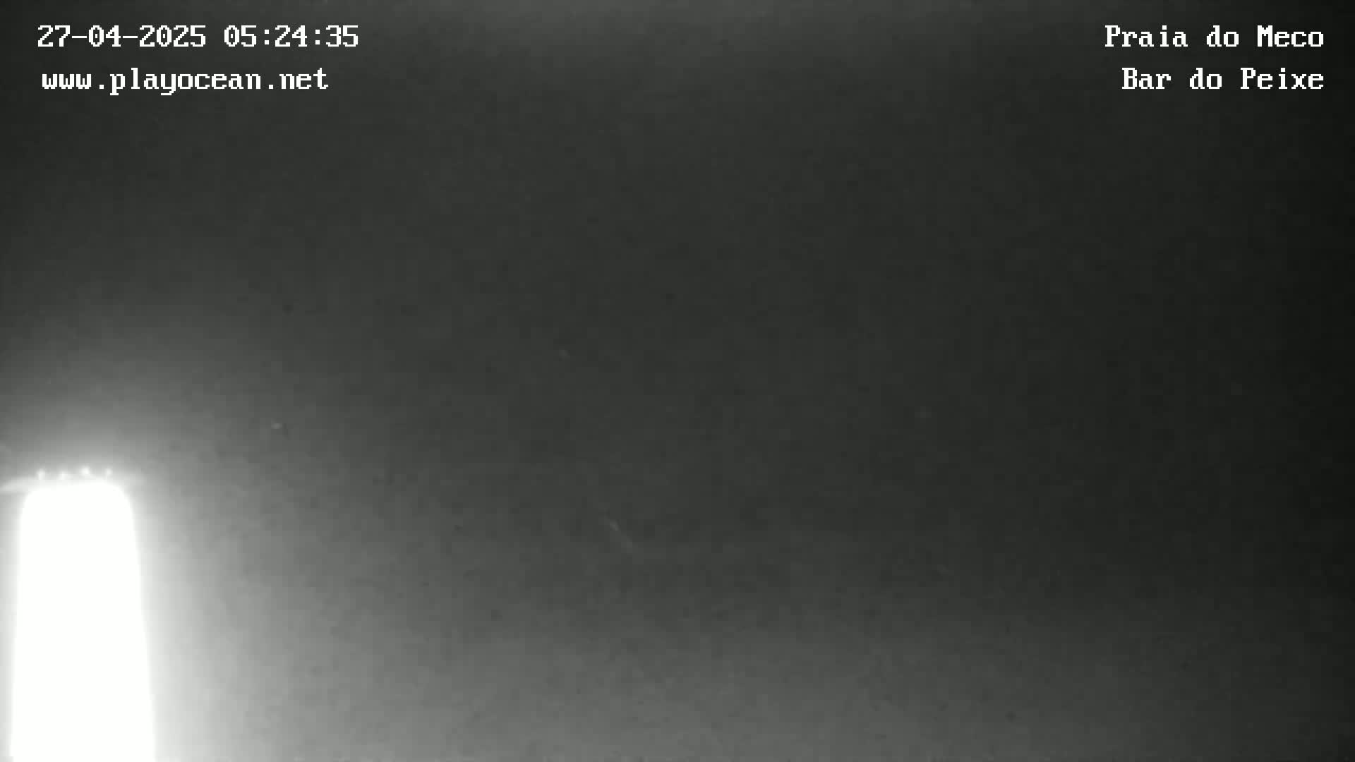 A bright light source is visible on the left side of a dark, nighttime scene.