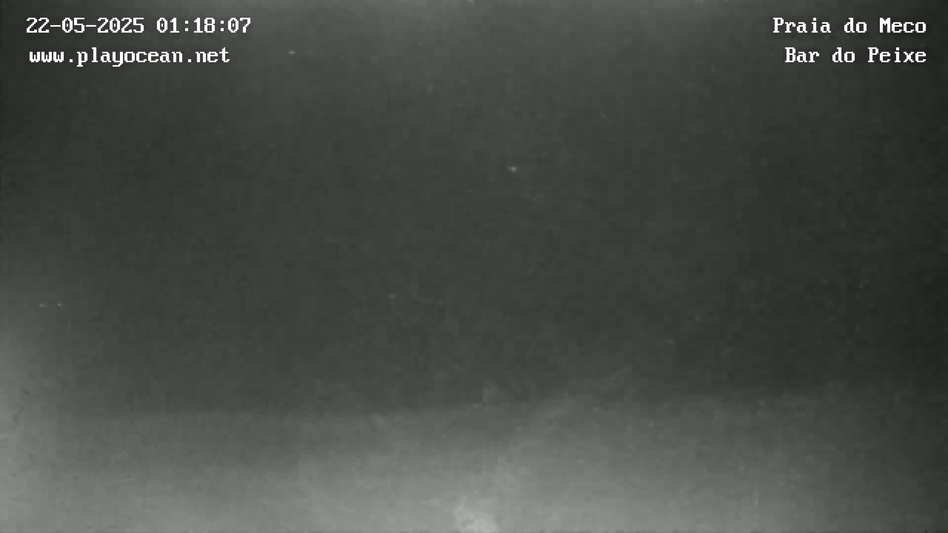 A dark, nighttime image shows a hazy, overcast sky over a dimly lit landscape.