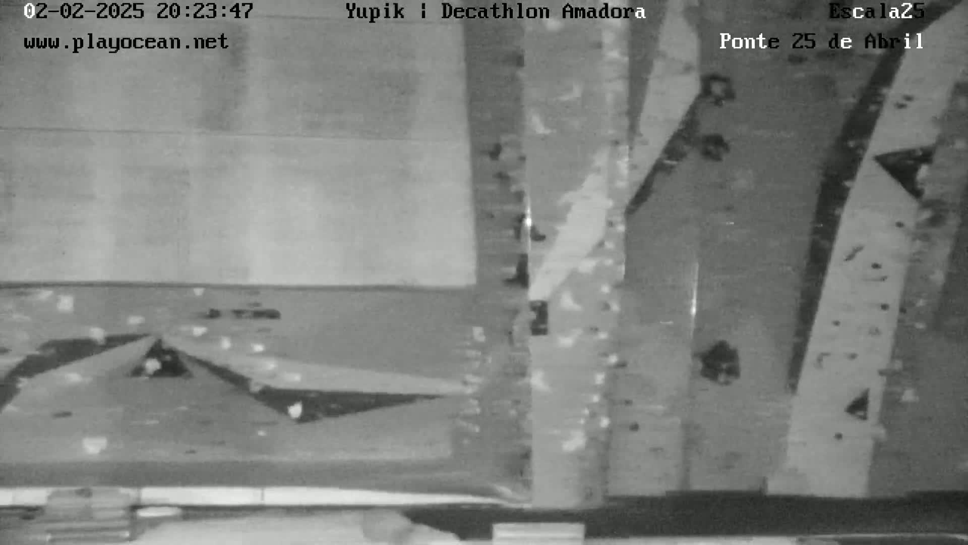A grainy, black-and-white nighttime image shows an overhead view of what appears to be a climbing wall.