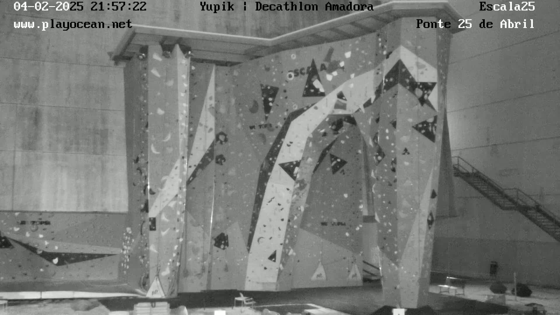 A large indoor climbing wall with various holds is shown in a grayscale image.