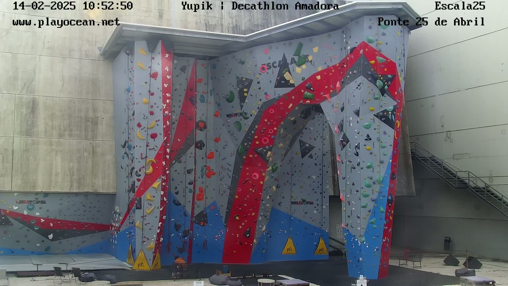 A large, colorful indoor climbing wall is shown.