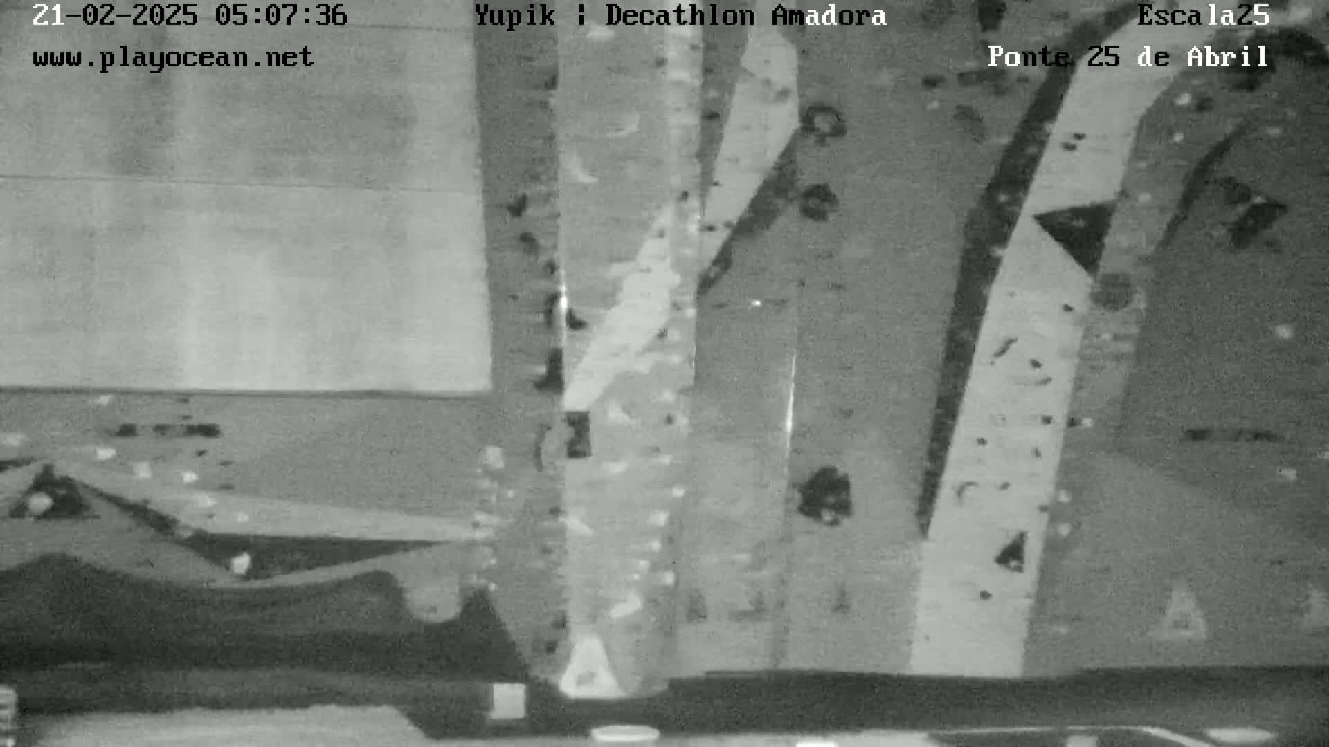 A grayscale image shows a wall with numerous climbing holds arranged in various patterns and heights.
