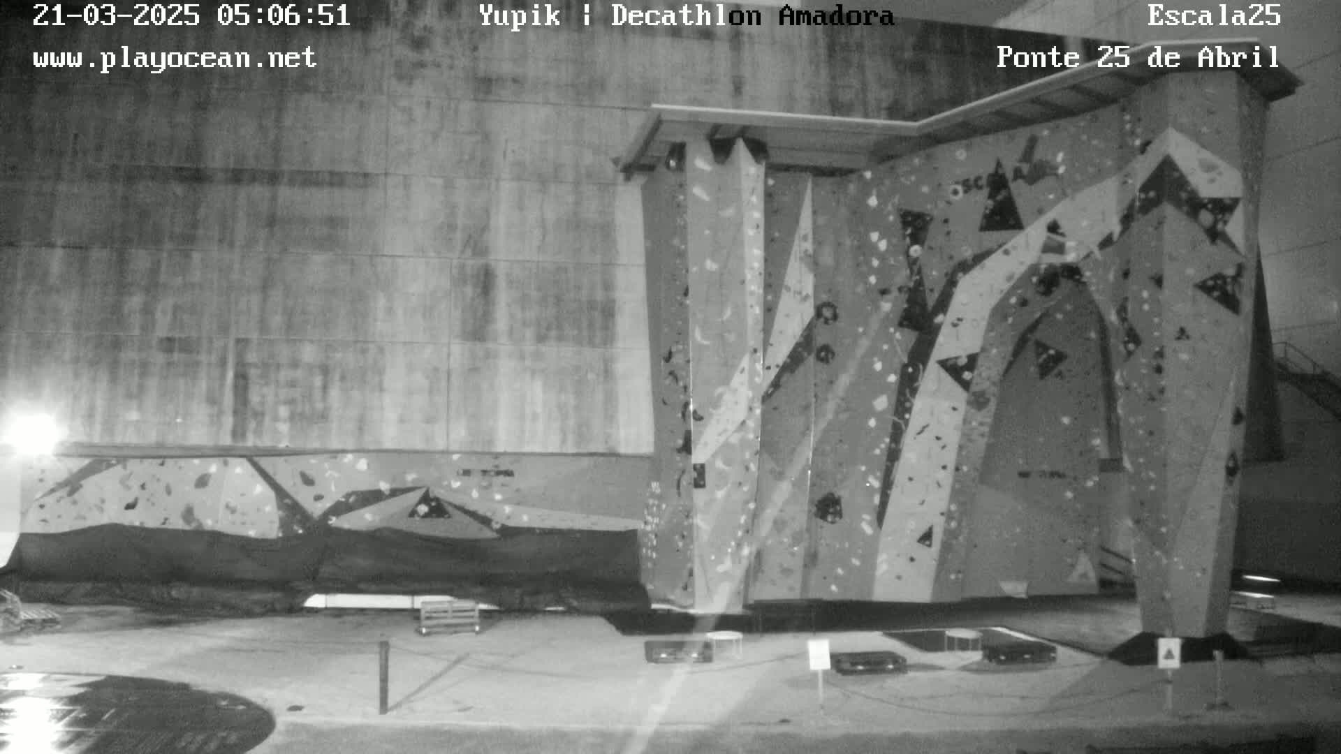A large indoor climbing wall stands under dim nighttime lighting.