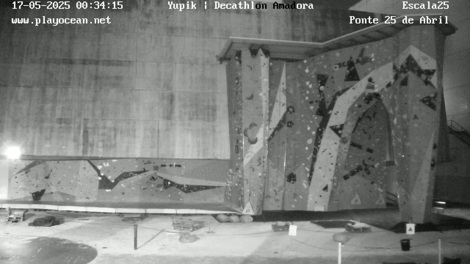A large indoor climbing wall is shown in a black and white nighttime image.