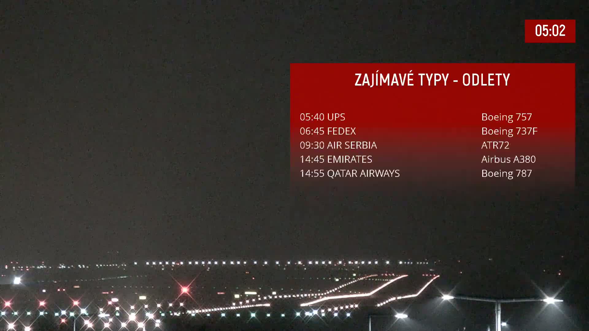 A nighttime view of an airport runway illuminated by lights.