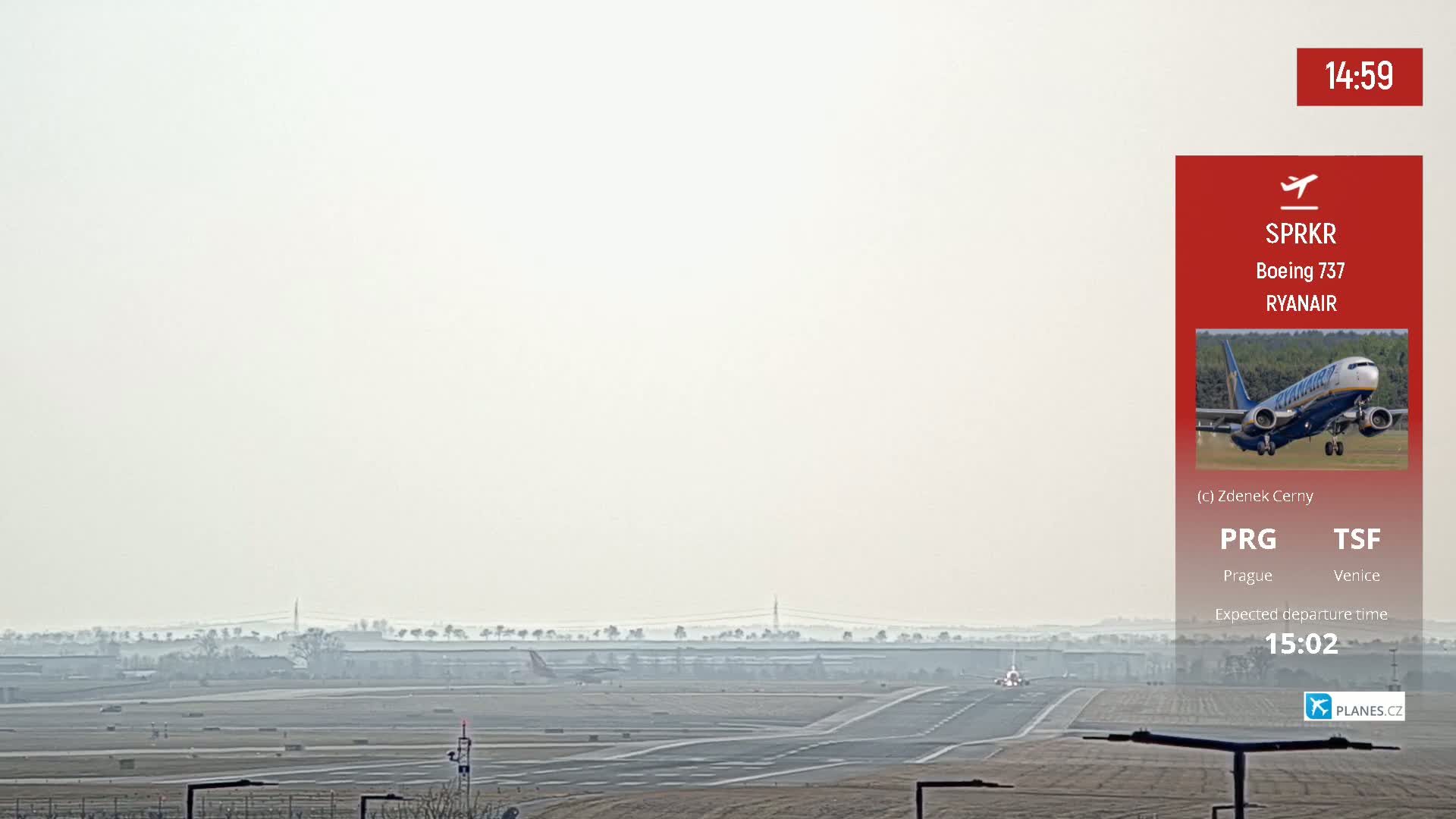 A hazy view of an airport runway with a single airplane taxiing, visible in the distance.