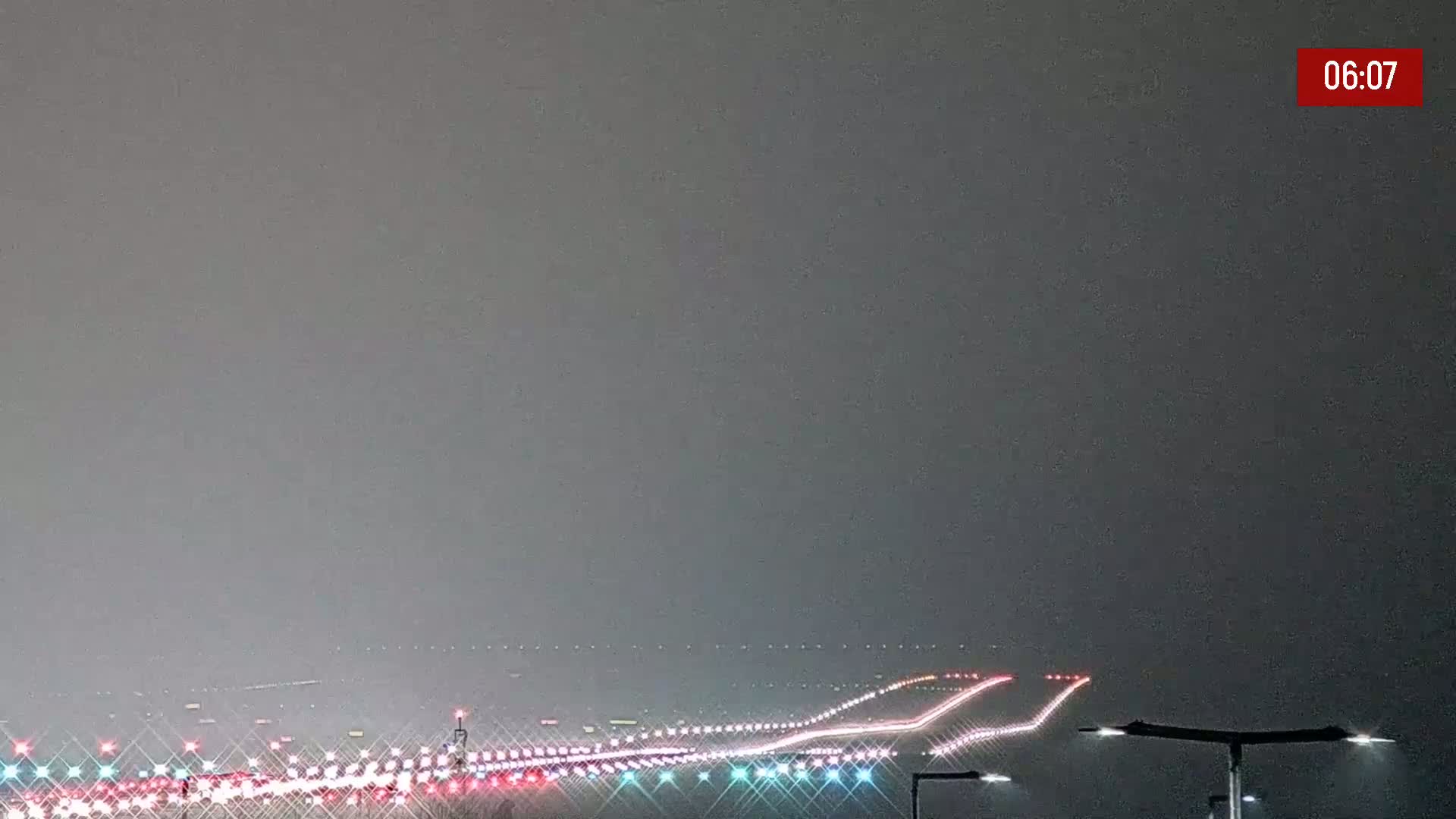 A long runway with lights extending into a hazy, overcast night.