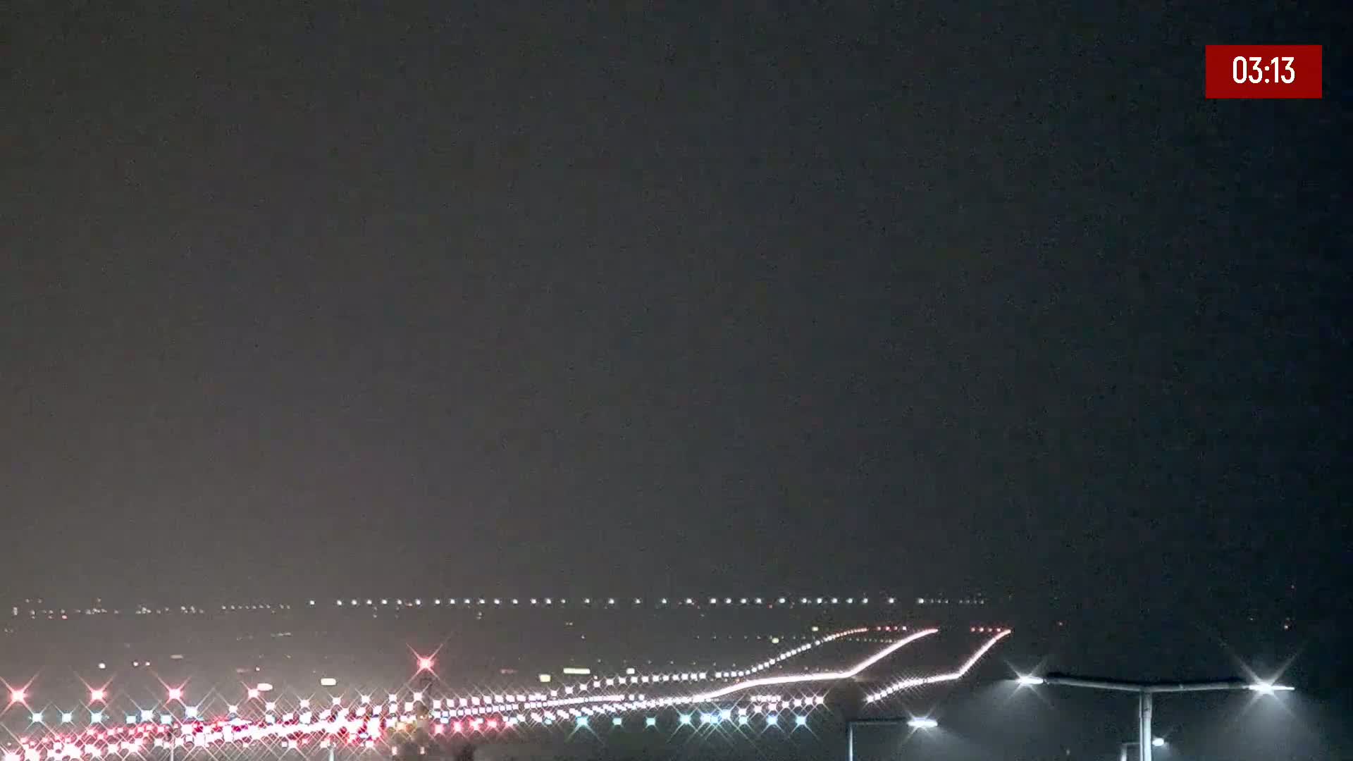 A nighttime view of a highway with heavy traffic under hazy or foggy conditions.