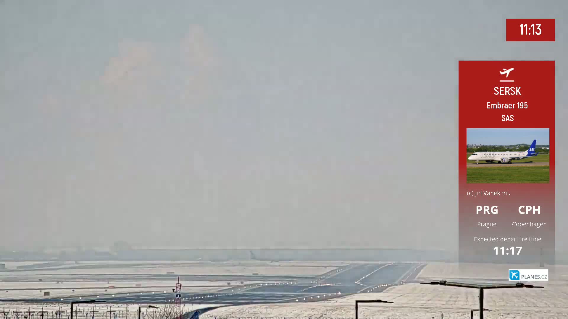 A snow-covered airport runway is visible under a hazy sky.
