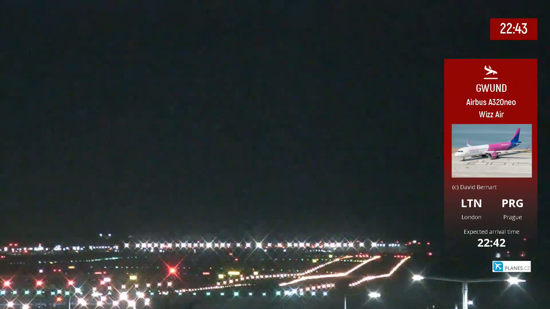 A nighttime view of an airport runway with lights illuminating the tarmac under a dark sky.