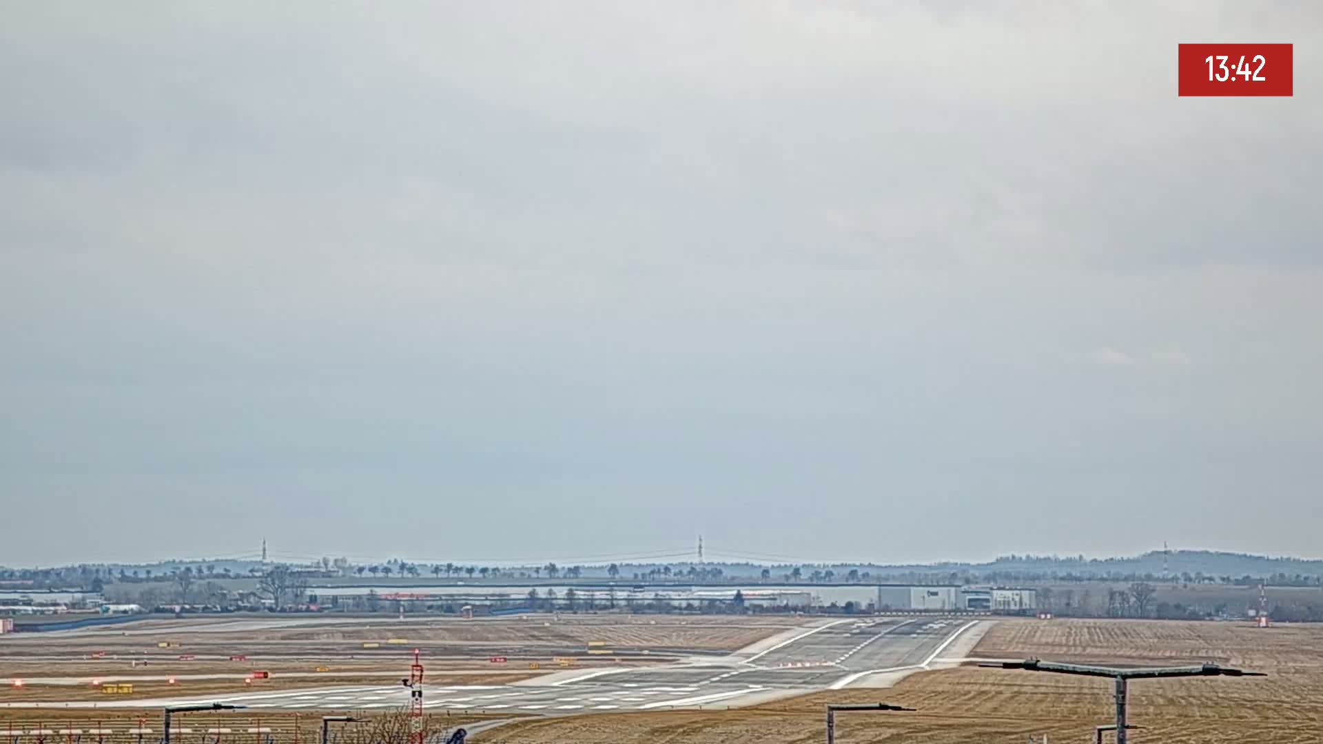 An airport runway is visible under an overcast sky.