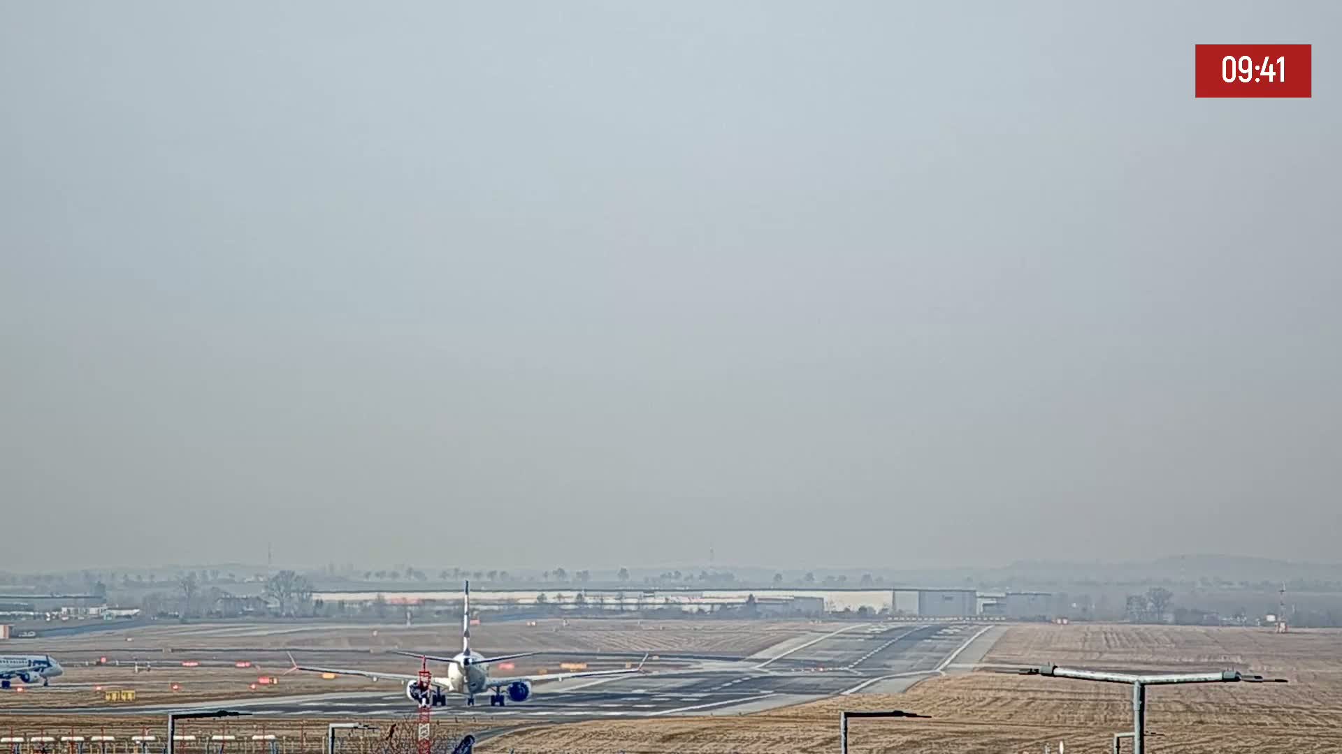 A passenger airplane taxis on a runway on a hazy day.