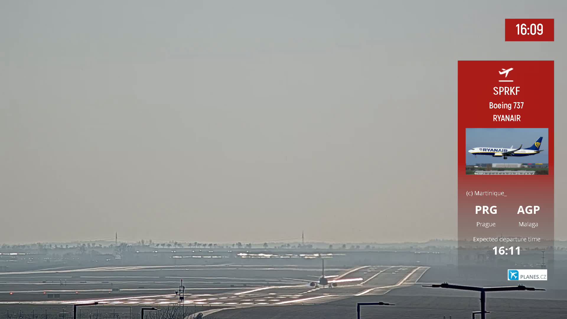 A Ryanair Boeing 737 airplane taxis on a runway under hazy conditions.