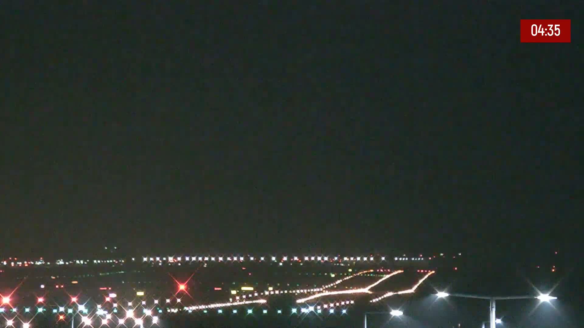 A nighttime view of a runway with lights illuminated under a clear, dark sky.