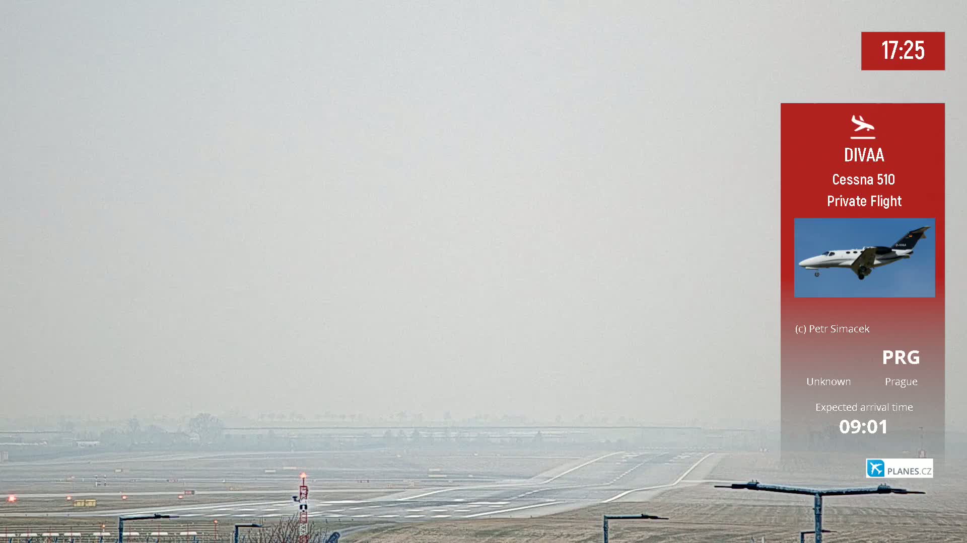 A hazy view of an airport runway with a private jet expected to arrive.