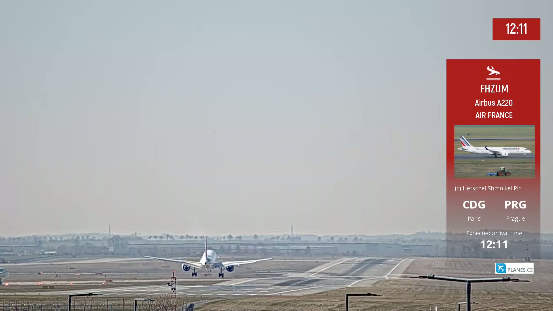 An Air France Airbus A220 airplane is landing on a runway under hazy conditions.