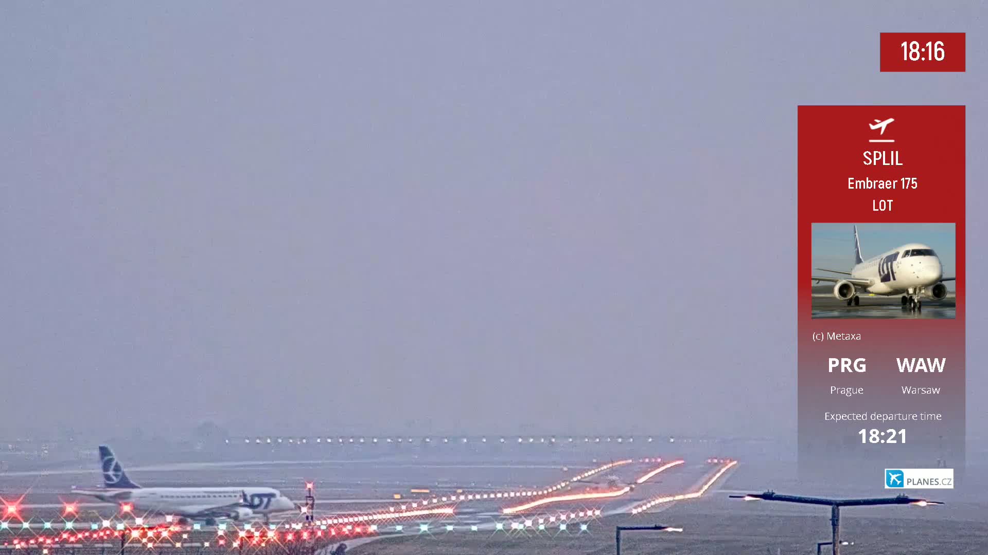An airplane taxis on a runway under hazy conditions at an airport.