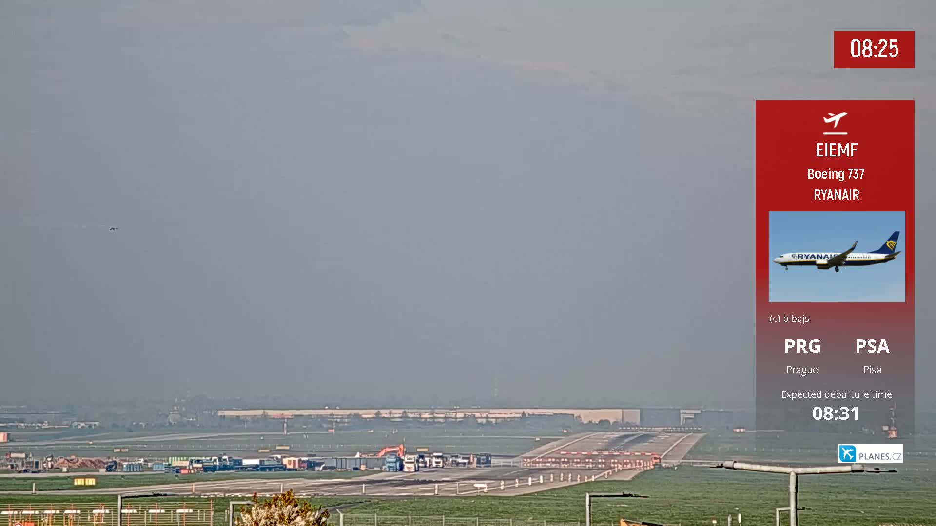A hazy view of an airport runway with several trucks and construction equipment, and a single airplane visible in the distance.