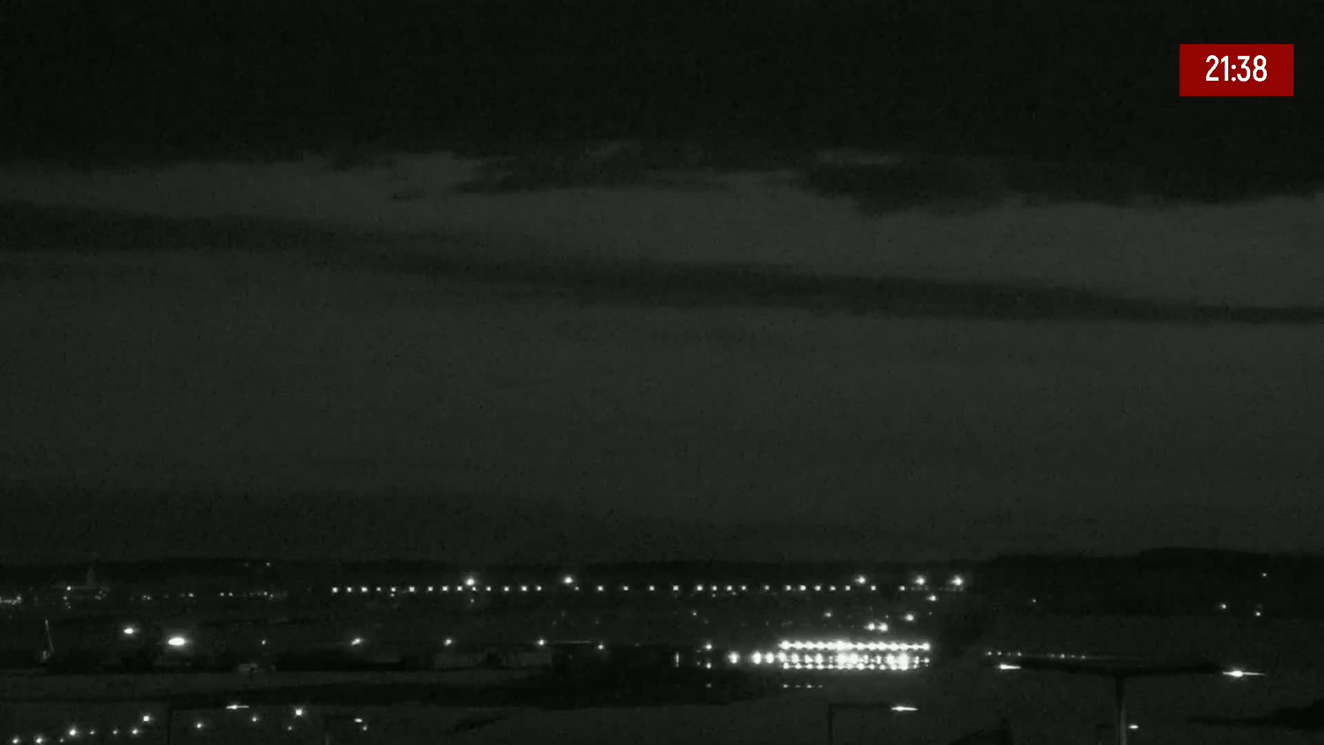 A nighttime view of a distant city skyline under a mostly clear, dark sky.