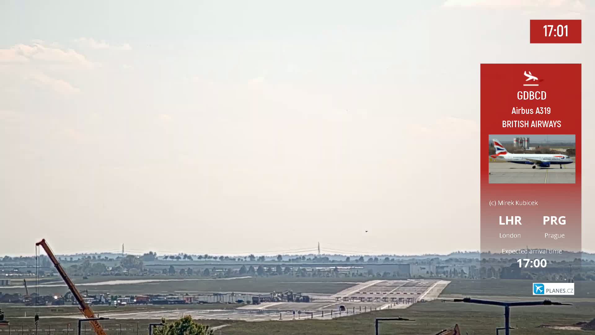 A British Airways Airbus A319 airplane is on the tarmac at an airport on an overcast day.