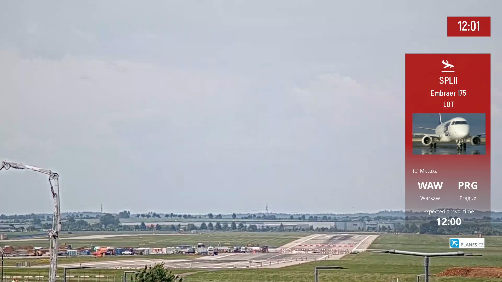 A view of an airport runway with construction equipment and a single airplane visible on the tarmac under a mostly cloudy sky.