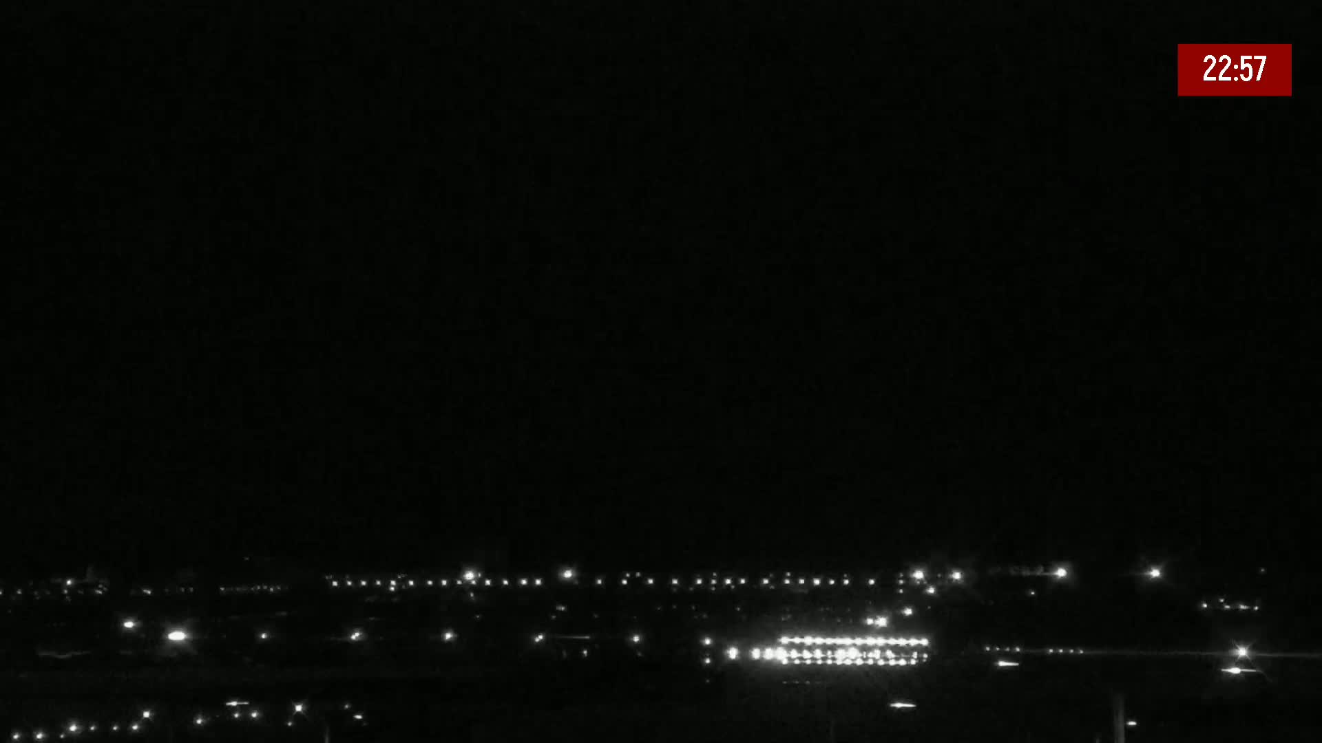 A hazy, sunny day reveals an airport runway with construction equipment and vehicles near the terminal.